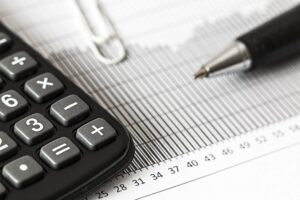 Close up of spreadsheet, pen, and calculated used for real estate accounting