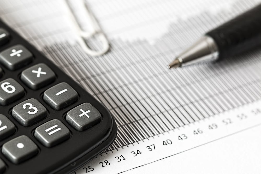 Close up of spreadsheet, pen, and calculated used for real estate accounting